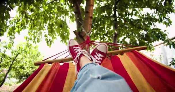 穿红鞋的脚踩在花园里的吊床上 — 图库视频影像