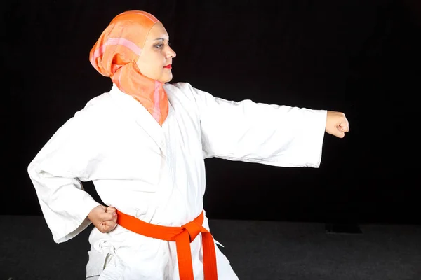 Ung muslimsk kvinna i kimono och hijab i karate övningar. Skytte närbild. — Stockfoto