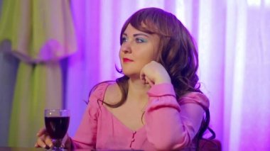 Kafede bir bardak kırmızı şarapla yalnız genç bir kadın..