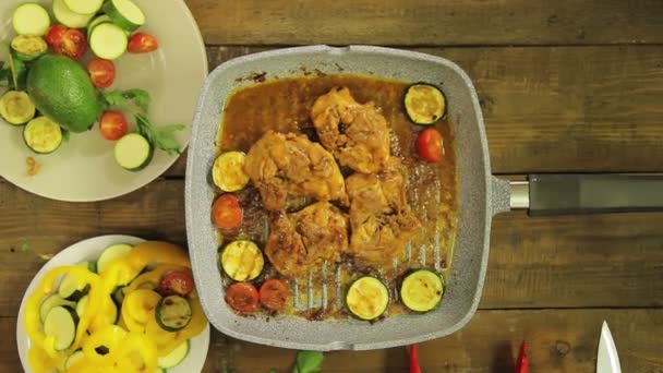 Female hand puts vegetables in chicken pieces in a grill pan. — Stock Video