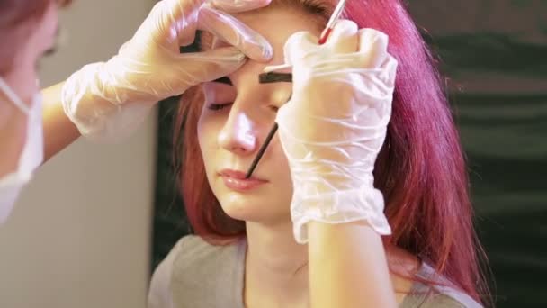 The beautician washes away the excess henna from the client s eyebrows — Stock Video