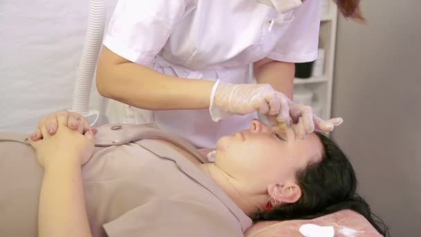 L'esthéticienne fait la correction des sourcils de la pâte à sucre cliente . — Video