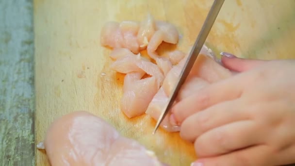 Женская рука режет курицу на куски ножом. . — стоковое видео