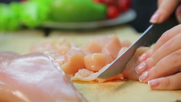 La mano femminile taglia il pollo a fette con un coltello . — Video Stock