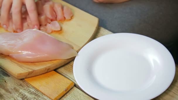 La mano femenina transfiere el pollo del tablero al plato . — Vídeos de Stock