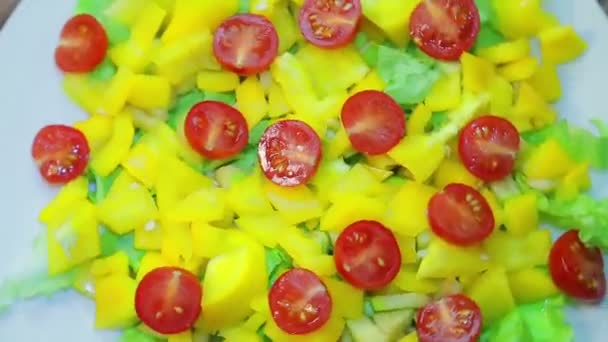 A salada vegetal fresca em uma chapa branca gira em um círculo . — Vídeo de Stock