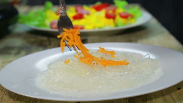 Las zanahorias coreanas se colocan en un plato con funchose — Vídeos de Stock