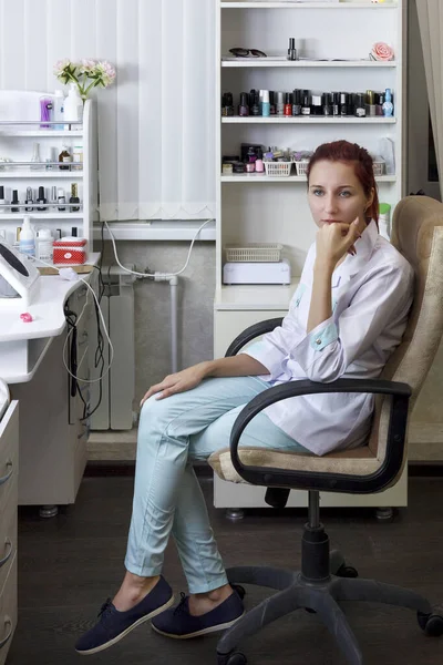 Manicurista in un salone di bellezza in attesa di un cliente. Piano globale . — Foto Stock