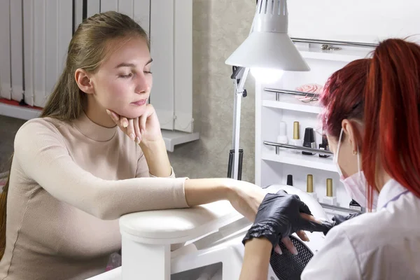 Un manicure in un salone di bellezza rende un cliente una manicure hardware che si prepara per il rivestimento in gel . — Foto Stock
