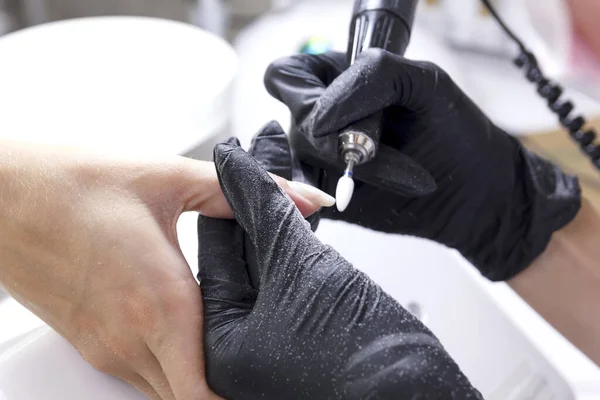 Manicurista rende cliente hardware manicure mani di grandi dimensioni . — Foto Stock