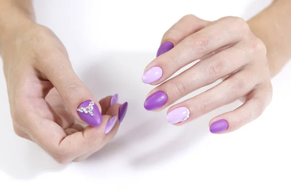 Manos de un cliente con esmalte de gel de manicura de dos colores y pedrería . — Foto de Stock