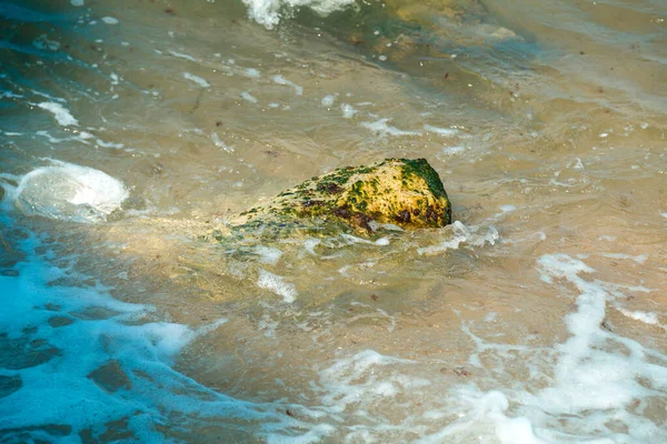 Fragments of stones near the sea shore in the water washed by the waves. — Stock Photo, Image