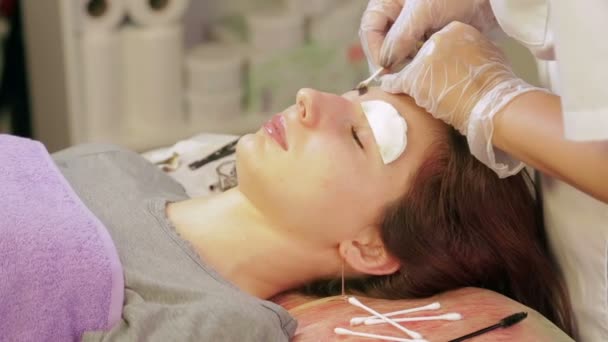 Косметолог моет хну с бровей клиента и наносит специальный крем — стоковое видео