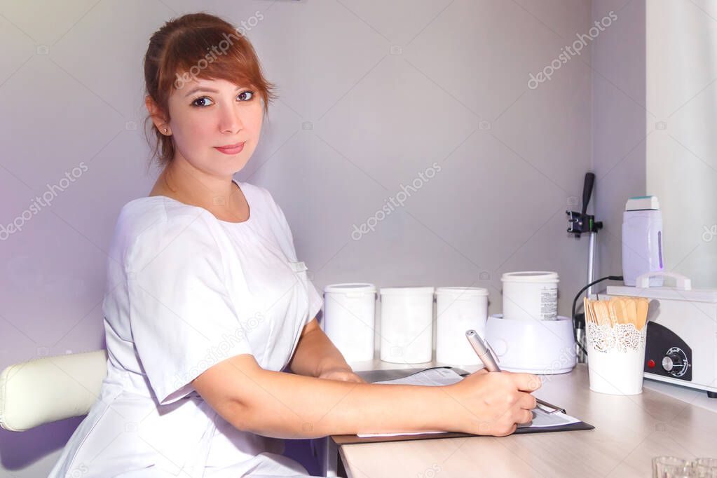 The beautician in the office draws up a contract for the client.