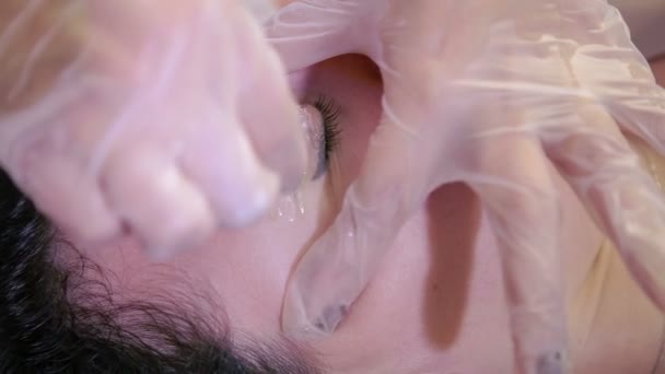 Красавчик исправляет брови клиентов расплавленным воском — стоковое видео