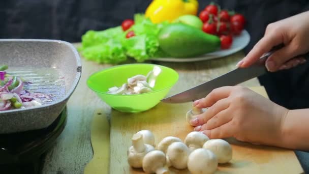 Vrouwelijke handgesneden champignon champignons op een houten plank — Stockvideo