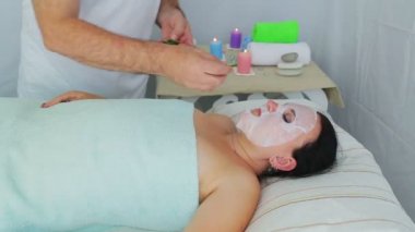 Bir erkek güzellik bir spa salonunda yüzünde bir kadın müşteri bir sebze terapisi yapar