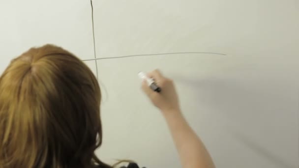 Une femme se tient debout avec son dos et dessine un graphique sur un tableau blanc. Laps de temps — Video