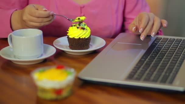 Vrouwelijke handen werken op een computer, eten gebak en neem koffie — Stockvideo