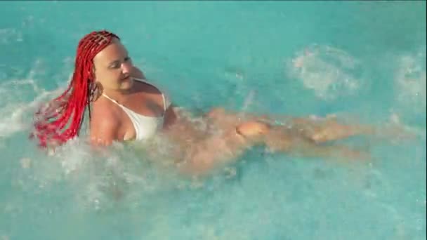 La mujer en la piscina hace un hidromasaje bajo corrientes de agua — Vídeo de stock