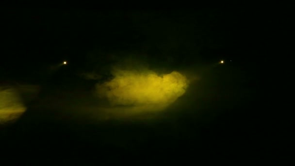 Ljus genereras gul profil spotlights i mörker i en rökfilt — Stockvideo