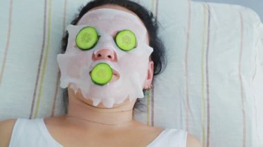 Bir erkek güzellik bir spa salonunda yüzünde bir kadın müşteri bir sebze terapisi yapar.