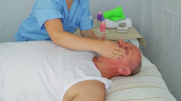 女性美容师在水疗沙龙给客户一个男人的脸按摩 — 图库视频影像