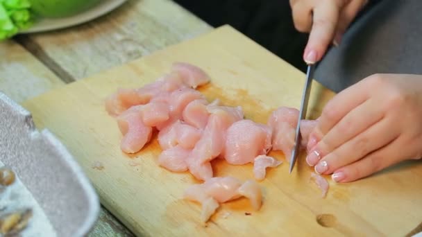 De vrouwelijke hand snijdt de kip in plakjes met een mes — Stockvideo