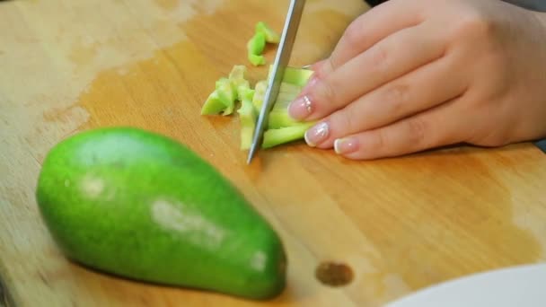 Kvinnliga handskivor avokado i bitar för sallad — Stockvideo