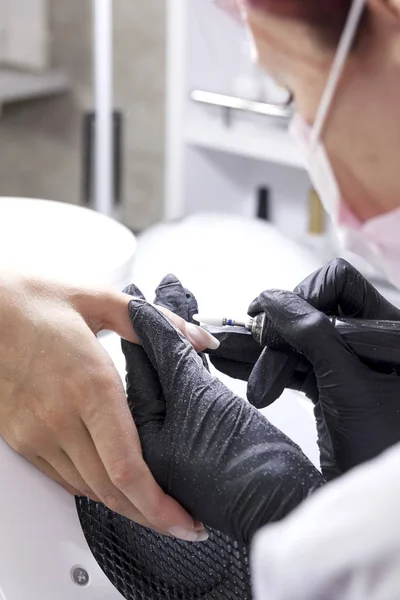 Manicure maakt klant hardware manicure handen groot. — Stockfoto