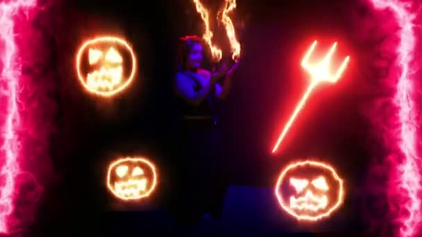 Женщина-дьявол танцует с огненными ручьями на руках, окруженная огненными лицами на черном фоне — стоковое видео