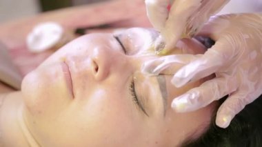 Beautician erimiş balmumu ile müşterilerin kaşları düzeltir