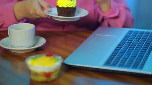 As mãos femininas trabalham em um computador, comem bolos e tomam café . — Vídeo de Stock