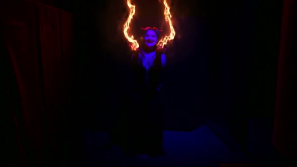 Una mujer disfrazada de demonio baila con fuego ardiendo en sus brazos — Vídeos de Stock