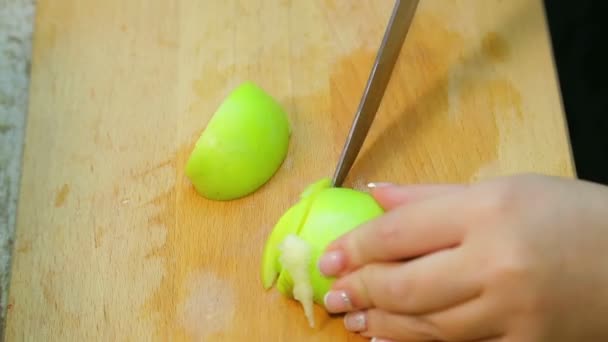 La mujer corta la manzana para la ensalada en la tabla de madera . — Vídeo de stock