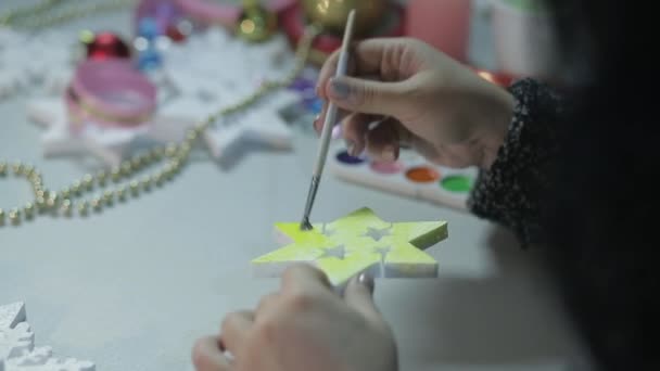 महिलाओं के हाथ पानी के रंगों के साथ सफेद रिक्त स्थान पेंट करके क्रिसमस के लिए घर सजावट बनाते हैं — स्टॉक वीडियो