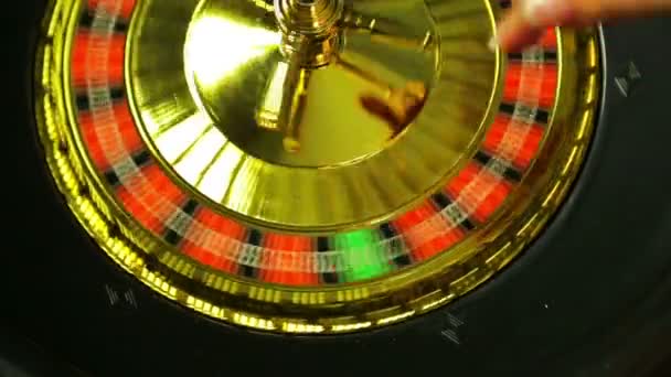A woman croupier in a casino starts roulette and throws a ball — Stockvideo