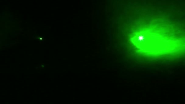 Green rays of light profile spotlights in a smoke blanket. — Stock Video