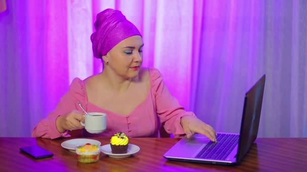 Uma mulher judia casada em um café na cabeça bebe café feio e trabalha no computador . — Vídeo de Stock
