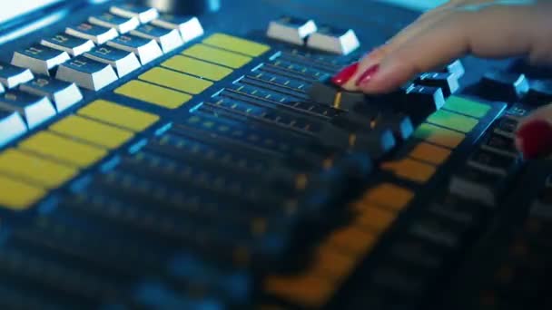 The illuminators hand sets up the mixing light console and prescribes programs for the performance — ストック動画