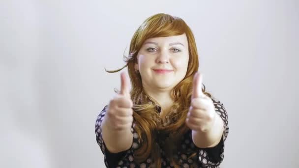 Une jeune femme sur fond blanc montre émotionnellement une classe avec ses mains — Video