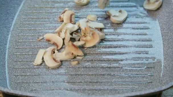 Nedskuren champignon-svamp placeras i pannan — Stockvideo