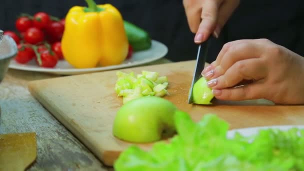 Mulher corta uma maçã de salada em uma tábua de madeira . — Vídeo de Stock