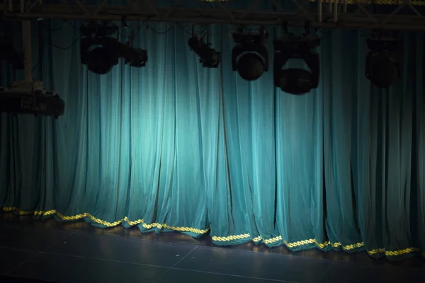 Tiyatro sahnesi ve sahne ışıkları performansın önünde..