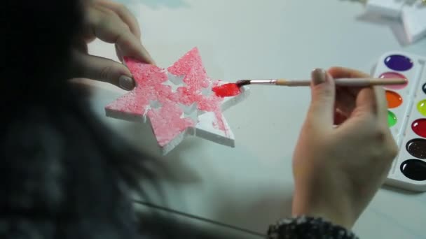 女性の手は、水彩で白いブランクを描くことによってクリスマスのための家の装飾を作る — ストック動画
