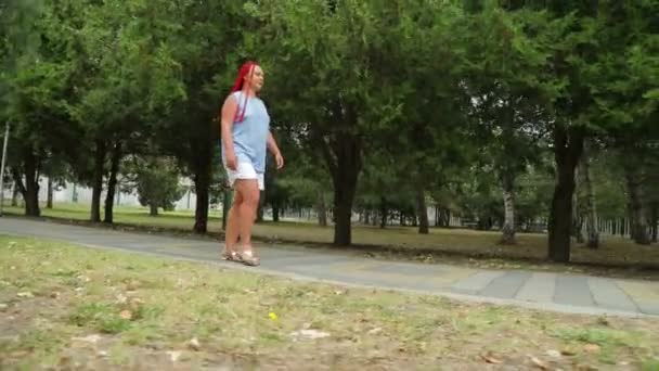 녹색 골목을 따라 걷고 있는 공원의한 여자 — 비디오