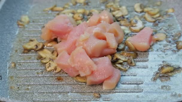 La mano femminile trasferisce il pollo in una pentola con champignons fritto . — Video Stock