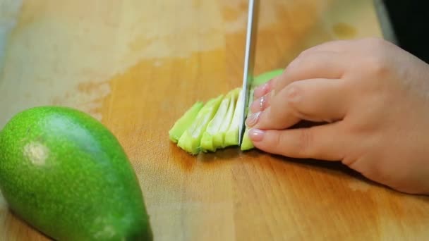 Kadın eli, avokadoyu salata için parçalara ayırıyor. — Stok video