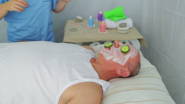 Kosmetikerin macht Gemüsetherapie im Gesicht eines Mannes. — Stockvideo