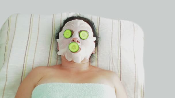 En manlig kosmetolog gör en kvinnlig klient en vegetabilisk terapi på hennes ansikte i en Spa salong. — Stockvideo